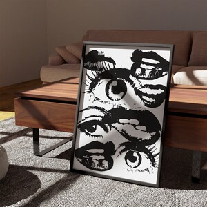 Puede incluir: Impresi&oacute;n de arte abstracto en blanco y negro con un primer plano de varios ojos y labios. La impresi&oacute;n est&aacute; enmarcada en un marco negro y se muestra en una mesa de madera.
