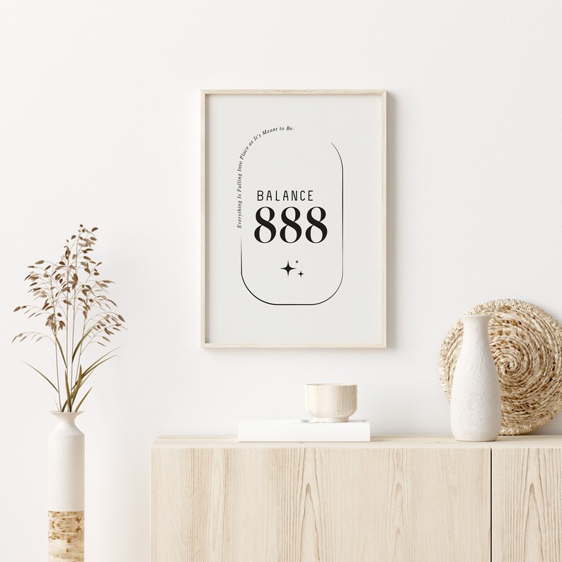 May include: A framed print with a white background and black text that reads "BALANCE 888" inside a rounded rectangle. The text "Everything is Falling into Place as It's Meant to Be." is written vertically along the right side of the rectangle.