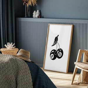 May include: Black and white illustration of a cherry with two eight ball pool balls as the cherries. The illustration is framed and hanging on a wall.