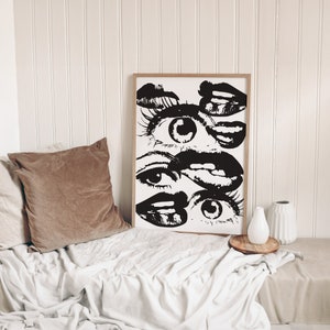 Puede incluir: Impresi&oacute;n de arte abstracto en blanco y negro con un dise&ntilde;o en capas de ojos y labios. La impresi&oacute;n est&aacute; enmarcada en un marco de madera simple.