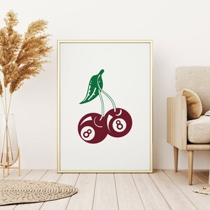 May include: A white framed print with a green and red illustration of two cherries. Each cherry is a billiard ball with the number 8 on it.