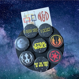 May include: A collection of eight circular pin-back buttons featuring Star Wars designs, including text that reads I LOVE YOU, I KNOW, STAR WARS, and MAY THE FORCE BE WITH YOU, alongside icons of the Death Star, Jedi Order, Rebel Alliance, and Empire.