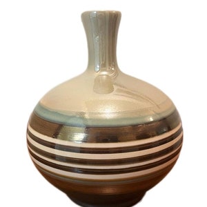 May include: A ceramic vase with a round body and a narrow neck. The vase is decorated with brown, white, and blue stripes.