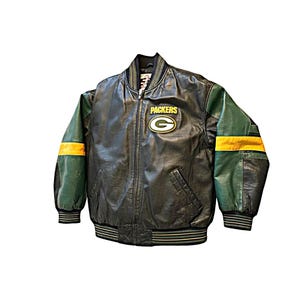 Op de afbeelding: Een zwart leren varsity-jack met groene mouwen en gele strepen. Op de borst bevindt zich een geel-groene Packers-logopatch met de tekst PACKERS erboven. Het jack heeft een ritssluiting aan de voorzijde en een geribbelde kraag, boorden en zoom.