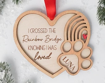 May include: Wooden heart-shaped ornament with a rainbow and paw print design. The ornament reads "I crossed the Rainbow Bridge knowing I was loved" and "Luna".
