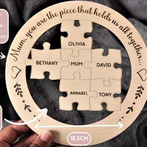 Może przedstawiać: Okrągła drewniana układanka z napisem "Mum, you are the piece that holds us all together..." wok&oacute;ł krawędzi. Układanka składa się z sześciu element&oacute;w z wygrawerowanymi nazwami: "Olivia", "Bethany", "Mum", "David", "Annabel" i "Tony". Układanka ma średnicę 18,5 cm.