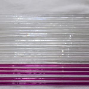 Könnte beinhalten: Eine Ansammlung klarer Glasstrohhalme, mit einem Abschnitt aus leuchtend magenta Strohhalmen am unteren Rand. Die Strohhalme sind in parallelen Linien angeordnet und erzeugen einen visuellen Kontrast.