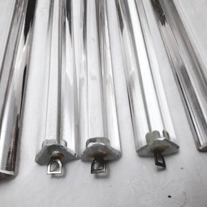 Puede incluir: Seis prismas de vidrio transparente con bucles de suspensión de metal. Los prismas son largos y rectangulares con un diseño facetado.