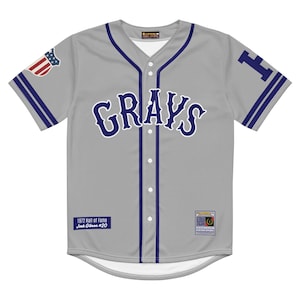 May include: A grey baseball jersey featuring the word "GRAYS" in navy blue script. The jersey has navy blue trim, an American flag patch on the sleeve, and the number "20" on the back. The jersey also has the text "1972 Hall of Fame Josh Gibson #20".