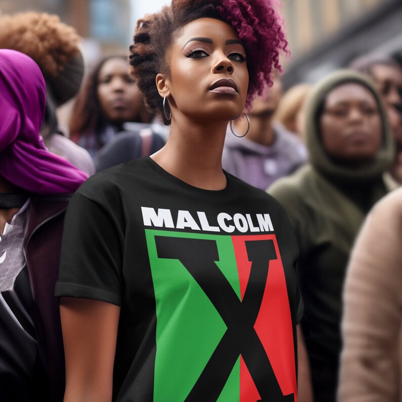 May include: A black t-shirt with a green, red, and black graphic of the letter X and the word "MALCOLM" printed in white.