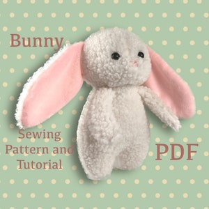 May include: A white and pink plush bunny sewing pattern and tutorial in PDF format. The bunny has black eyes and a pink nose. The background is a green polka dot pattern.