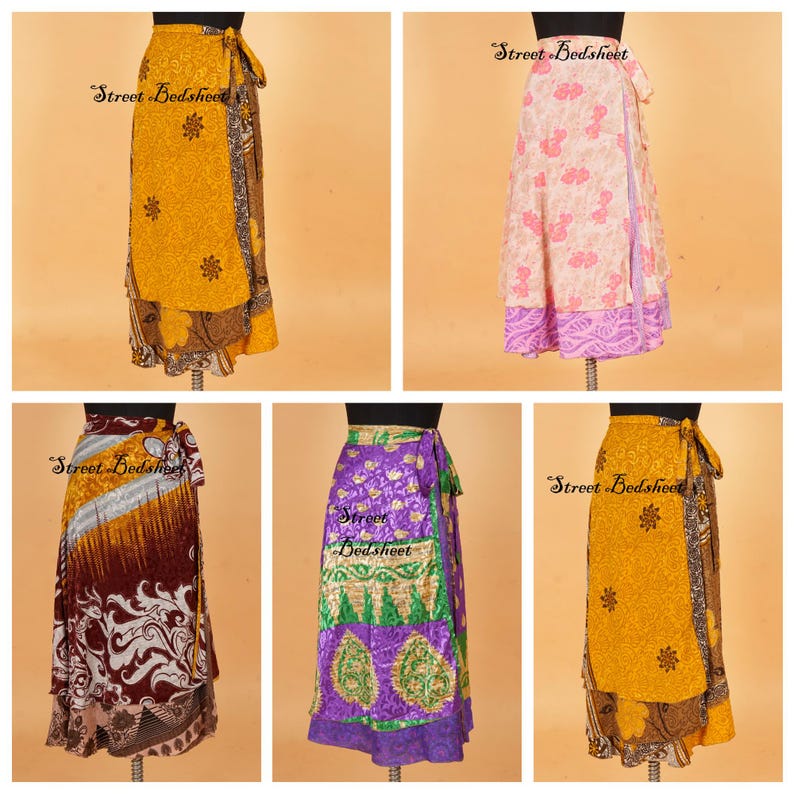 May include: Five wrap skirts displayed on mannequins, featuring various patterns and colors including yellow, pink, maroon, and purple. Each skirt has a side tie closure and a layered design with intricate floral and geometric prints throughout.