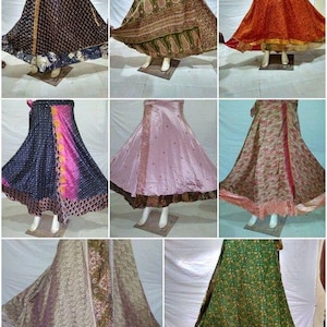 May include: A collection of eight floor-length wrap skirts featuring various patterns and colors, including black, green, orange, pink, and floral prints. Each skirt has a flared silhouette and is displayed on a mannequin to show the drape.