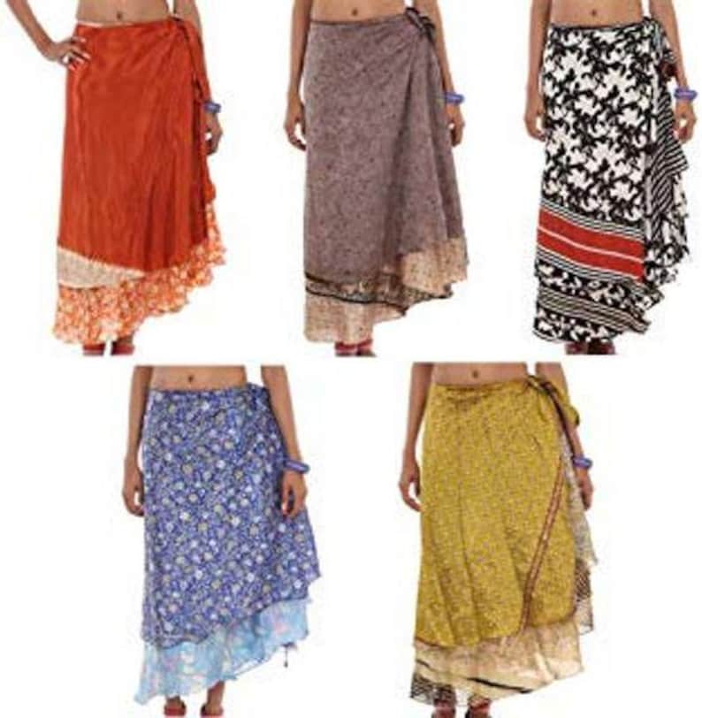May include: Five wrap skirts in various colors and patterns. The top row features a solid orange skirt with a floral hem, a grey patterned skirt, and a black and white floral skirt with a red stripe. The bottom row shows a blue floral skirt and a yellow patterned skirt.