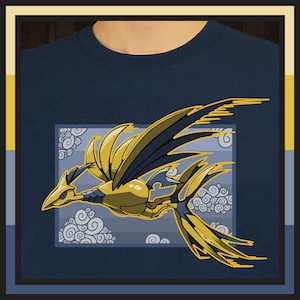 May include: Navy blue t-shirt featuring a stylized golden bird design with black accents, set against a cloudy sky background. The bird has detailed feathers and a dynamic pose, creating a striking visual.