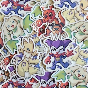 Peut inclure: Une collection d'autocollants de personnages de dessins animés colorés. Les autocollants présentent diverses créatures dans des tons de rouge, de violet, de jaune et de vert. Certains personnages ont de grandes oreilles et des queues, d'autres ont des griffes et des dents acérées.