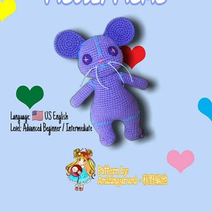 May include: A crocheted purple mouse amigurumi toy with white yarn for the whiskers and eyes. The toy has a stitched-on smile and a heart-shaped nose. The background is light blue with hearts in various colors.