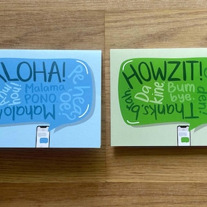 May include: Two greeting cards with a blue and green background. The blue card has a speech bubble with the word "ALOHA!" and other words in Hawaiian. The green card has a speech bubble with the word "HOWZIT!" and other words in Hawaiian. Both cards have a white phone icon in the bottom center.