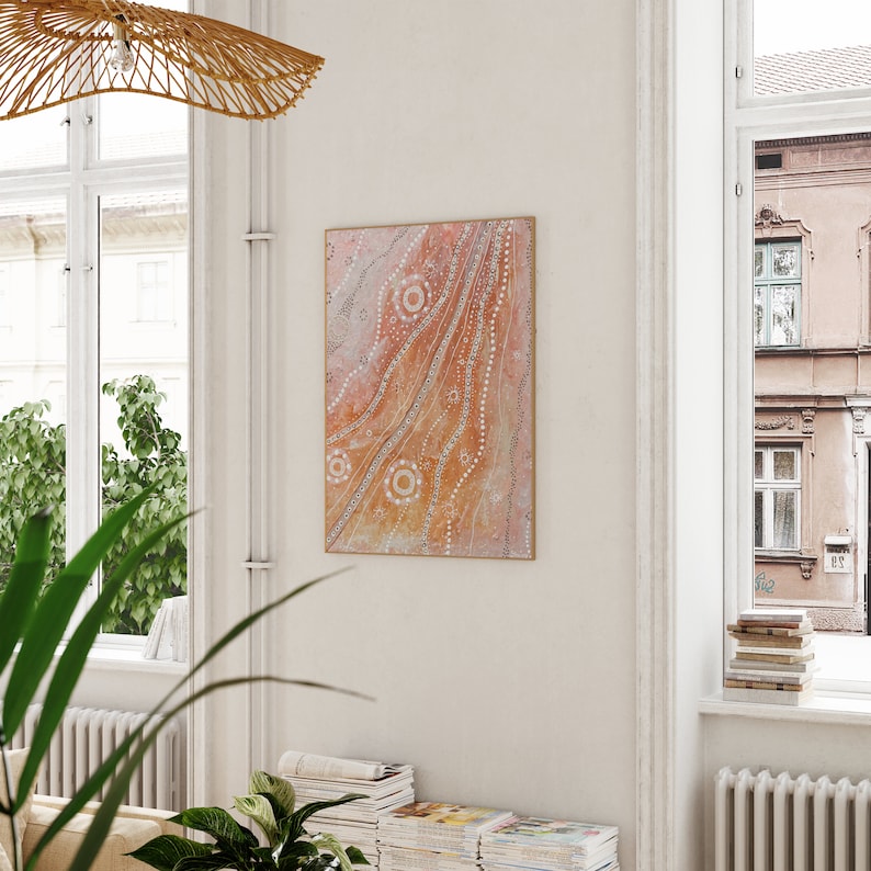 May include: A framed abstract painting with a light orange background and white dots and lines. The painting is in a modern style and would look great in a living room or bedroom.