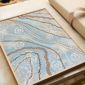 May include: A framed abstract painting with a blue background and brown and white lines and dots. The painting has a modern and minimalist style.