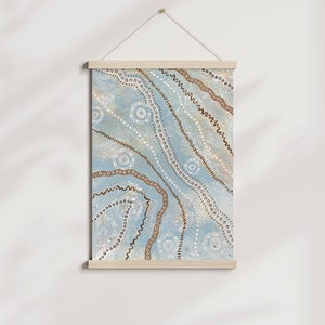 May include: A blue and brown abstract wall hanging with a geometric pattern of circles, dots, and lines. The hanging is framed with a natural wood frame.