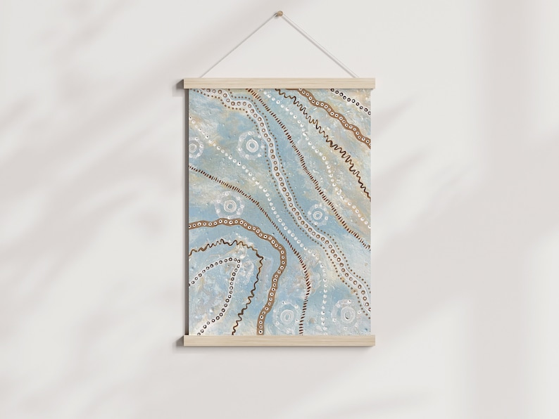 May include: A blue and brown abstract wall hanging with a geometric pattern of circles, dots, and lines. The hanging is framed with a natural wood frame.