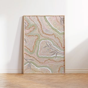 May include: A framed abstract painting with a light pink, brown, and green color scheme. The painting features a swirling pattern of lines and dots, reminiscent of Australian Aboriginal art.