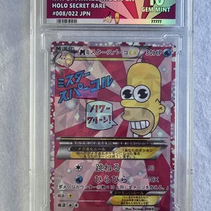May include: A graded trading card featuring a cartoon character, encased in a clear protective holder. The card is labelled "MR SPARKLE MEGA EX" and "HOLO SECRET RARE." The card is graded 10 GEM MINT.