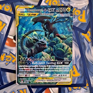 May include: A Pokemon trading card featuring Xenomorph & Bulbasaur, a Tag Team card with a blue, green, and black background. The card has a picture of a Xenomorph and a Bulbasaur. The card text reads "XenoLeaf Fusion" and "Bulbclutch Facehug GX".
