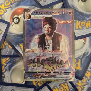 Peut inclure: Carte de collection holographique "Shazaam VMAX" avec 100 HP. L'image montre un homme portant un turban. Le texte comprend "Mandela Effect" et "Single Strike".