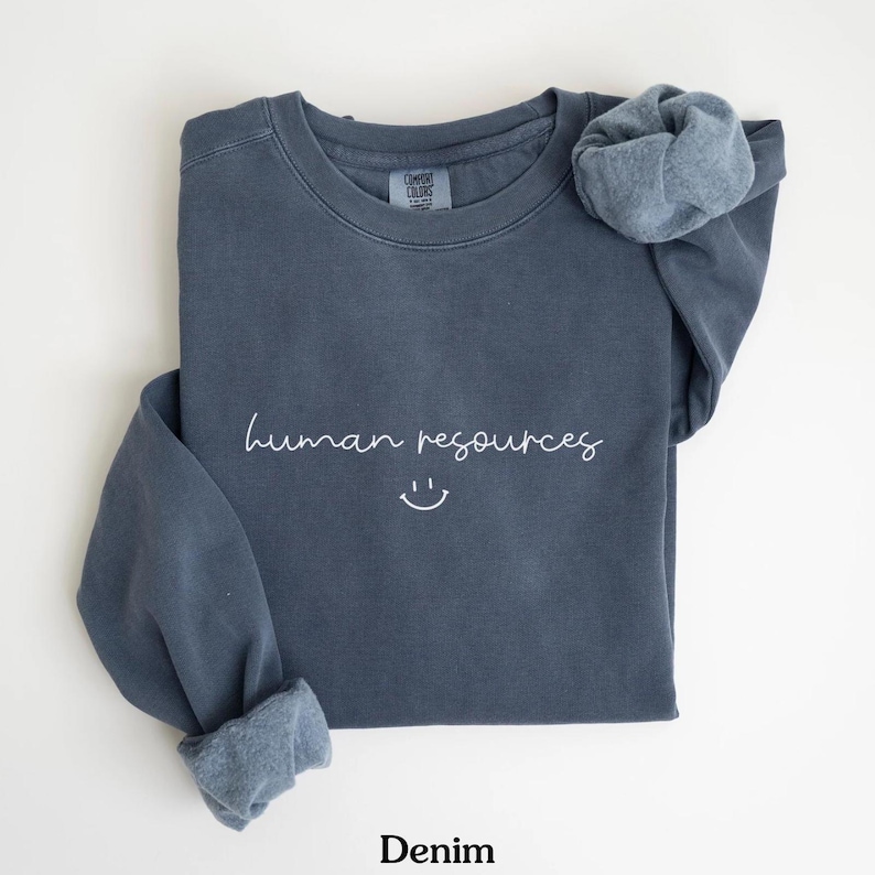 May include: A dark blue sweatshirt with the text "human resources" and a smiley face in white lettering.