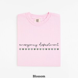 May include: Pink t-shirt with the text "emergency department" and a row of green hearts.
