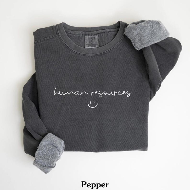 May include: A dark gray sweatshirt with the text "human resources" and a smiley face in white.