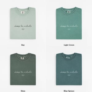 May include: Four folded t-shirts in different colors: bay, light green, moss, and blue spruce. Each shirt has the text "choose to include" and a smiling face printed on the front.