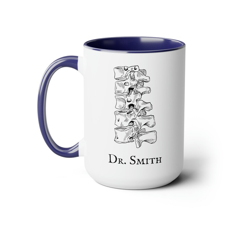 May include: White ceramic coffee mug with a blue rim. The mug features a black and white illustration of a human spine and the text "Dr. Smith".