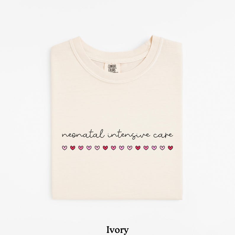 May include: Ivory t-shirt with the text "neonatal intensive care" and a row of pink and red hearts.