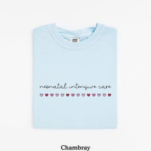 May include: Light blue t-shirt with the text "neonatal intensive care" and a row of pink and red hearts.