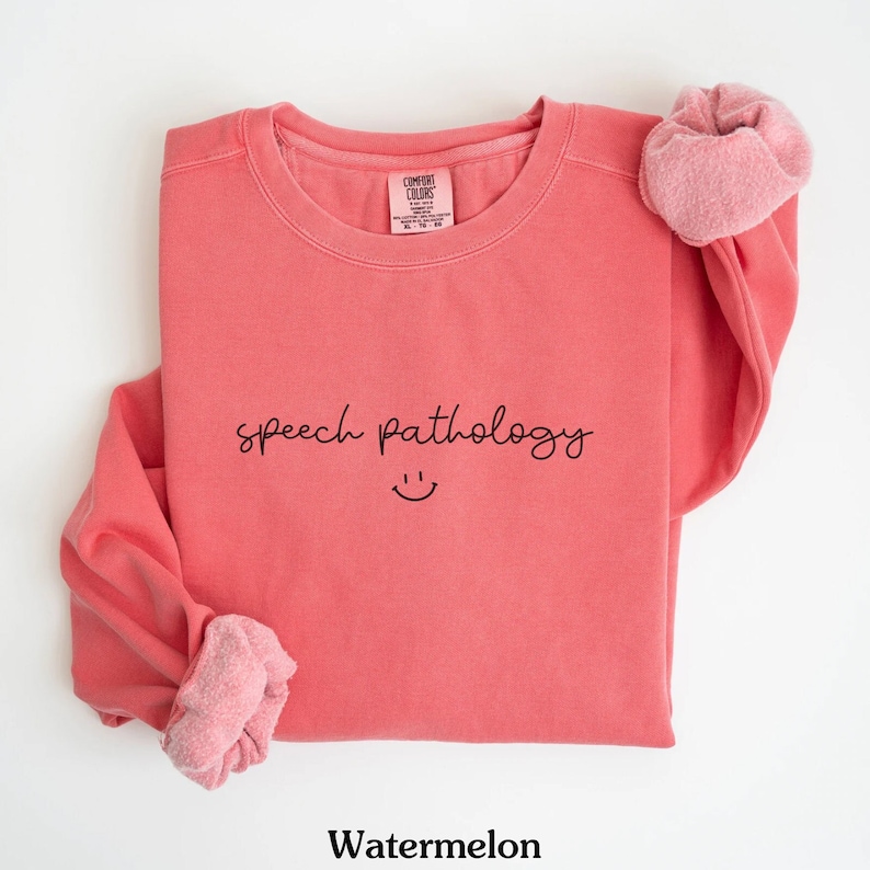May include: Watermelon colored sweatshirt with the text "speech pathology" and a smiley face.