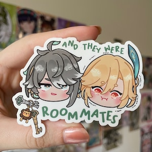 May include: A sticker featuring two cartoon characters with the text "And they were roommates". The characters are a young man with grey hair and a young man with blonde hair. The sticker is on a white background.
