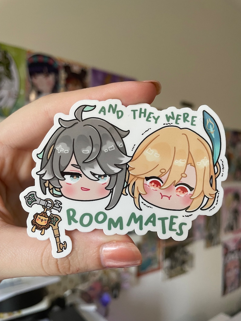 May include: A sticker featuring two cartoon characters with the text "And they were roommates". The characters are a young man with grey hair and a young man with blonde hair. The sticker is on a white background.