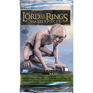 May include: A sealed pack of "The Lord of the Rings Masterpieces" trading cards. The packaging features an image of Gollum. The pack includes 7 art cards and lists special inserts like sketch cards and foil cards. The Topps logo is visible.