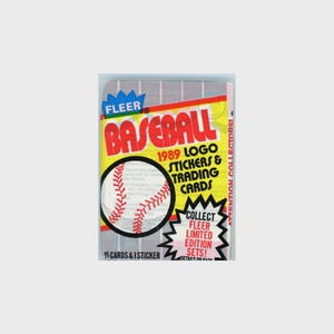 May include: A sealed pack of 1989 Fleer baseball trading cards. The packaging is primarily yellow, red, and black, with the word "BASEBALL" prominently displayed. The pack includes 15 cards and 1 sticker, and is a limited edition set.