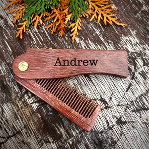 Peut inclure: Un peigne en bois avec une poignée pliable. La poignée est gravée du nom "Andrew".