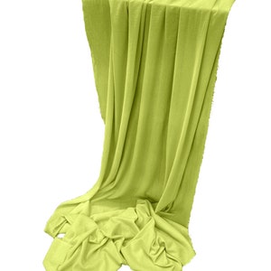 May include: A bright green fabric backdrop draped over a table. The fabric is smooth and has a slight sheen.