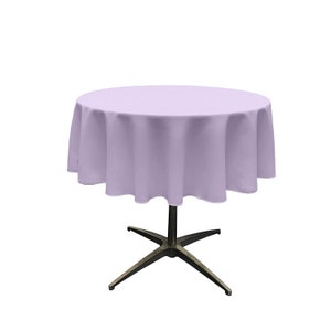 Op de afbeelding: Een ronde tafelkleed in lavendelkleur met een gladde, kreukvrije afwerking. Het tafelkleed is gedrapeerd over een ronde tafel met een eenvoudige, vierpotige basis.