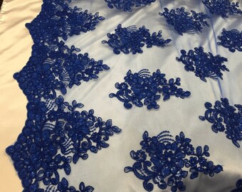Puede incluir: Tela de encaje floral azul real con un delicado fondo de malla. El encaje presenta intrincados diseños florales con pequeñas lentejuelas en todo.
