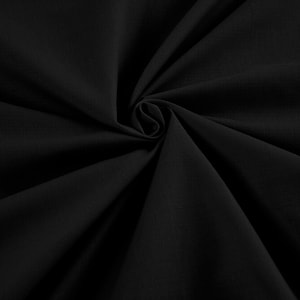 Puede incluir: Tela negra con textura lisa, doblada y retorcida en forma de espiral.