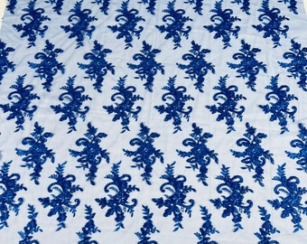 Puede incluir: Tela de encaje floral azul real con un patrón delicado. El encaje está sobre un fondo de malla transparente.