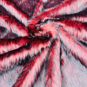 May include: Close-up of a red and black faux fur fabric. The fabric has a soft, plush texture and is perfect for crafting projects.