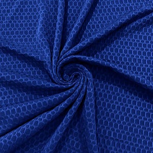 Op de afbeelding: Een close-up van een koninklijk blauwe stof met een textuur van een honingraatpatroon. De stof is zacht en heeft een subtiele glans.